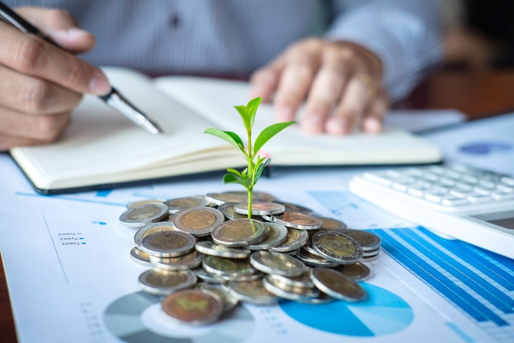 Businessman accountant making notes at report doing finances and calculate about cost of investment and analyzing financial data, growing business to profit and saving with wealth management.
