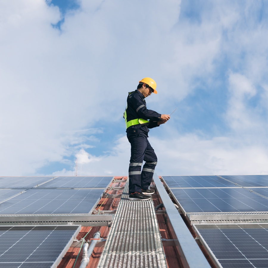 Service engineer checking solar cell on the roof for maintenance if there is a damaged part. Engineer worker install solar panel. Clean energy concept.